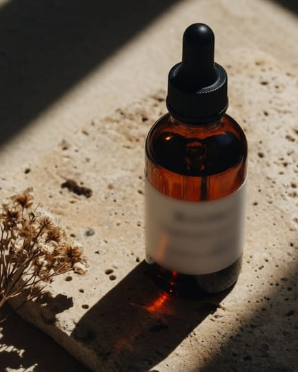 Eine bernsteinfarbene Serumflasche auf Stein in hartem Sonnenlicht